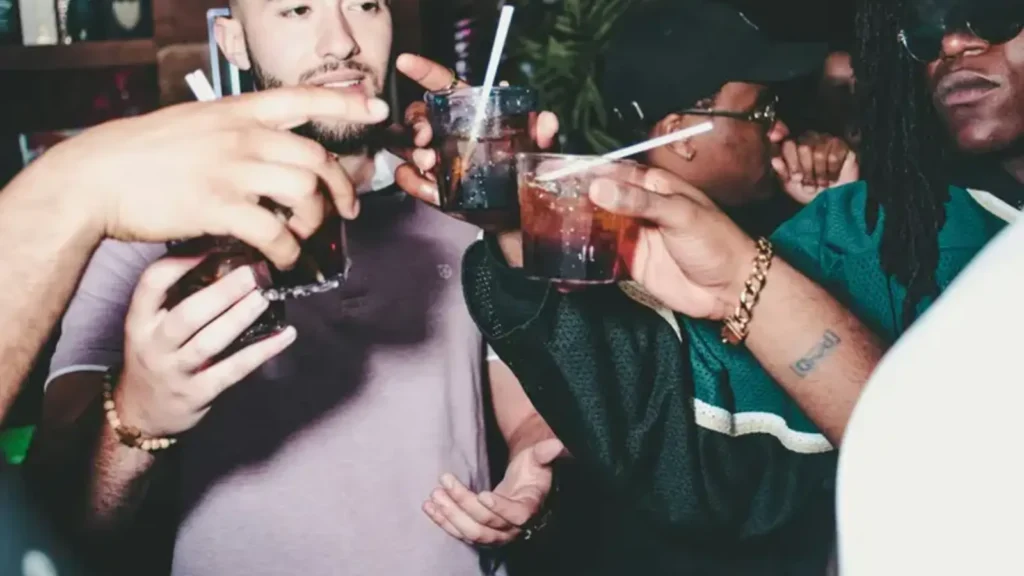 Friends raising drinks together in a dim bar