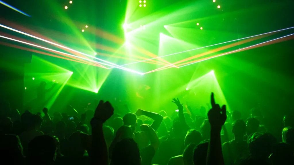 Público bailando bajo luces verdes en una discoteca