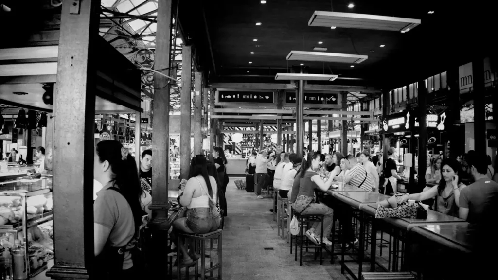 Personas charlando en un mercado y bar concurrido de Madrid
